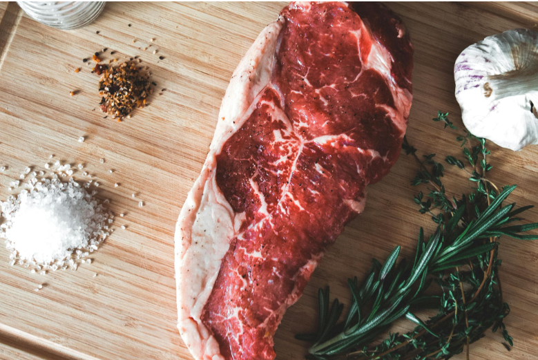 Striploin cut with different seasoning and aromatics before cooking