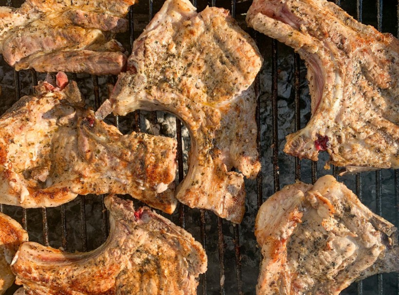 Numerous pork chops being grilled at the same time